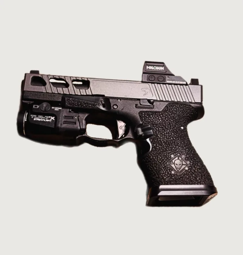 A complete stippled pistol fitted with a red dot sight