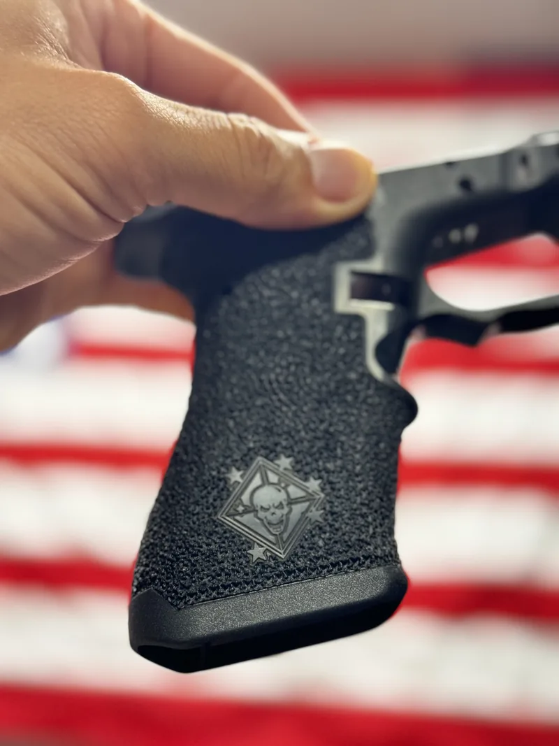 A stippled pistol grip held in the hand